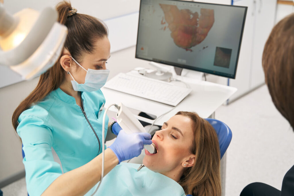 Dentist scanning woman teeth with dental intraoral - Oral Plastic Surgery & Periodontics