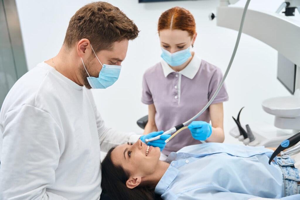 Professional dentist in uniform talking to female - Oral Plastic Surgery & Periodontics