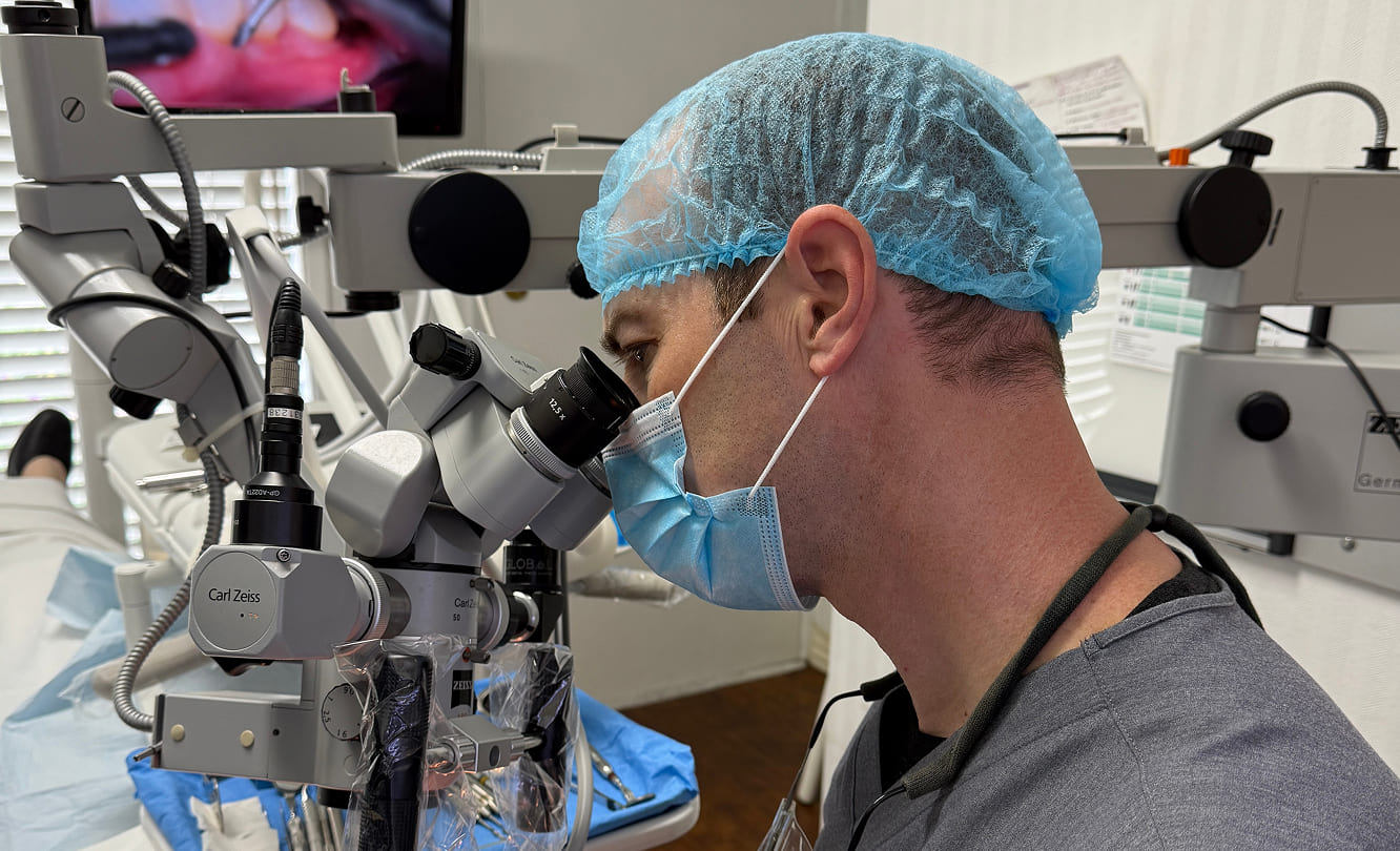 Dr Stephen Hutton performing precision periodontal plastic surgery using Carl Zeiss surgical microscope for minimally invasive gum treatment